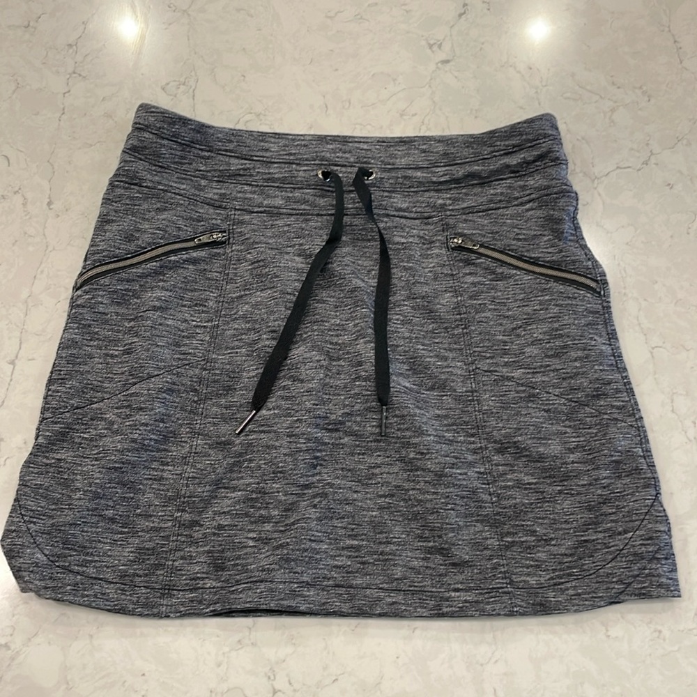 Athleta charcoal skort with side zip pockets, back pockets and tie waist.